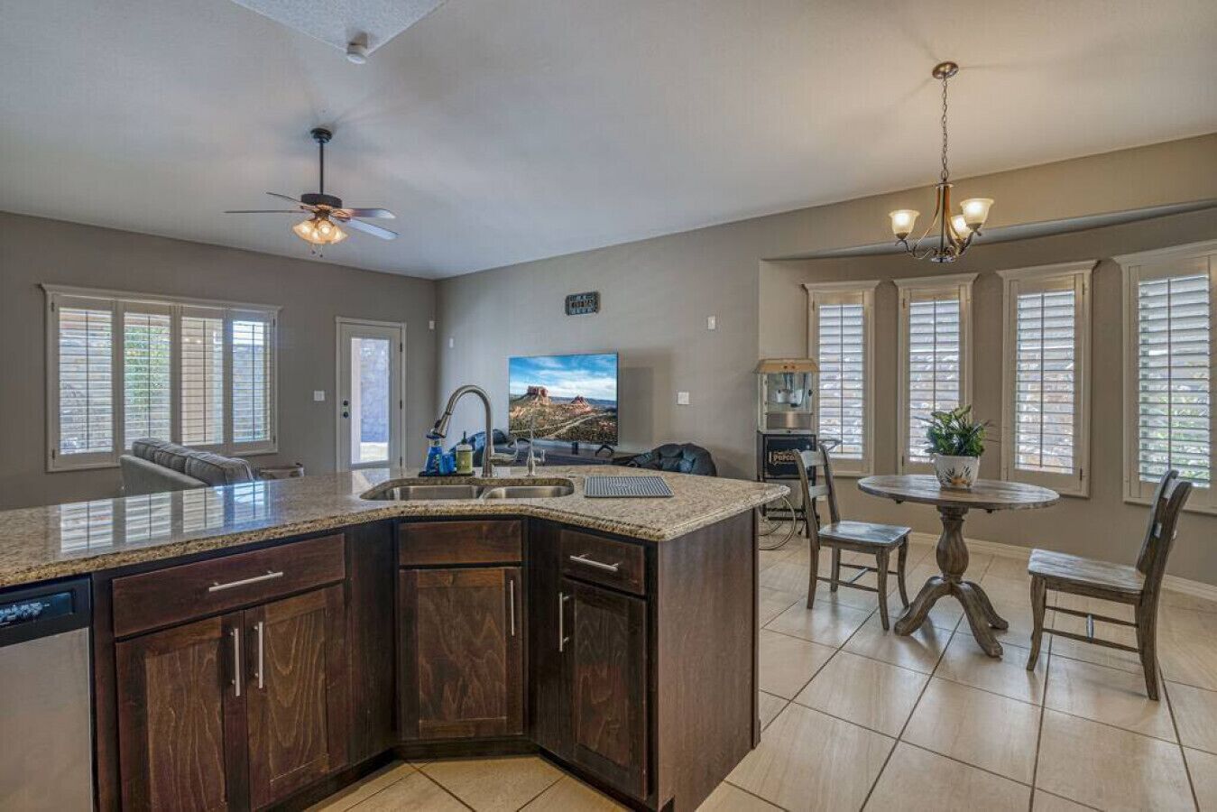 A spacious kitchen with a large island, dark wood cabinets, and a dining area with a round table and chairs.