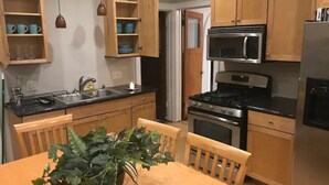 A kitchen with wooden cabinets, a stove, a microwave, and a sink.