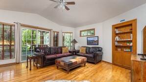 A spacious living room with leather sofas, a wooden coffee table, and a bookshelf. - The REAL BOISE RETREAT! AMAZING LOCATION & STELLAR Backyard. Bring your DOG! 2 mins to Downtown! (Boise)