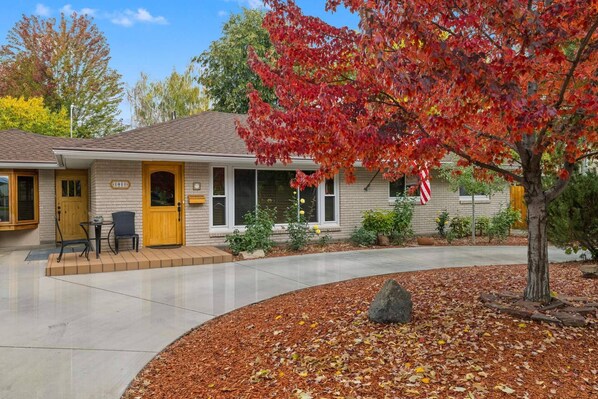 A single-story house with a front porch, a mailbox, and a small patio area.