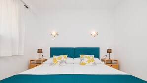 A bed with a teal headboard, white bedding, and two nightstands with lamps. - Apartment Drac Blanc 1-4 close to the Beach with Sea View, Pool, Terrace & Wi-Fi (CALA RATJADA)
