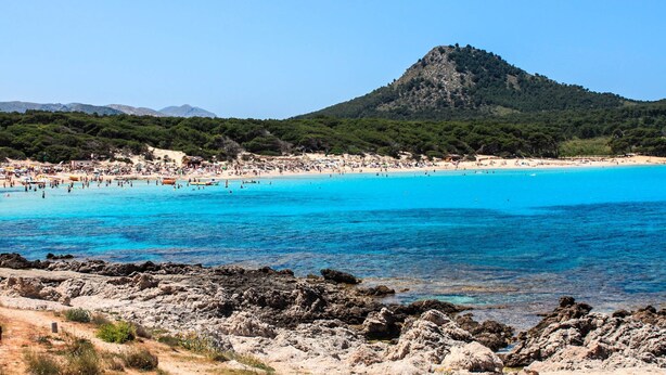 A coastal beach with clear blue waters, rocky shoreline, and a mountain in the background. - Apartment Drac Blanc 1-4 close to the Beach with Sea View, Pool, Terrace & Wi-Fi (CALA RATJADA)