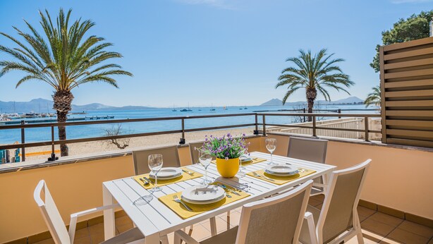 A table set for two with a view of the sea and mountains. - Stunning Apartment "Cana Ferrera" with Sea and Mountain Views, Balcony, A/C & Wi-Fi (Puerto de Pollensa)