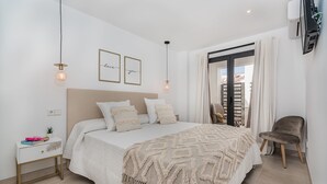 A bedroom with a bed, bedside table, lamp, and a view of the outside. - Stunning Apartment "Cana Ferrera" with Sea and Mountain Views, Balcony, A/C & Wi-Fi (Puerto de Pollensa)