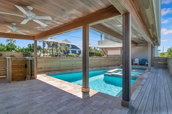 A covered outdoor swimming pool area with a wooden deck, ceiling fans, and a view of the surrounding neighborhood. - Salt Therapy - Elevated house w/ beach access (St Augustine)