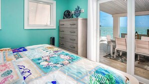 A bedroom with a bed, a dresser, a window, and a view of the ocean. - Dolfan Oceanfront Cottage Direct oceanfront with 50 ft of dockage and jacuzzi and kayaks 4 bed 2 bath home (Marathon)