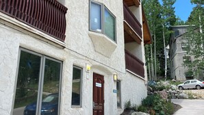 A multi-story building with a stone facade, large windows, and wooden balconies. - Spacious Shredder`s Lounge (Taos Ski Valley)