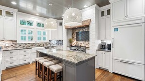 A spacious kitchen with a large island, white cabinetry, and a brick accent wall. - WaterColor Dream: Bikes, Electric Cart, WaterColor Beach Club Access, and Private Pool. (Santa Rosa Beach)