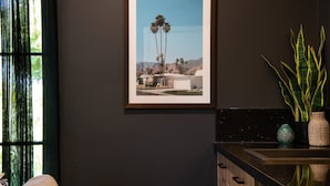 A framed photograph of a residential area with palm trees, a house, and mountains in the background. - East St 1 - tranquil escape, cosy charm (Daylesford)
