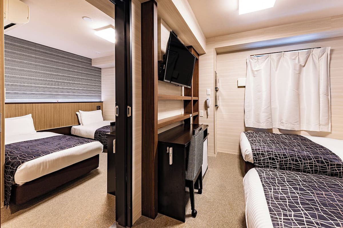 Ein gemütliches Schlafzimmer mit zwei Betten, einem Fernseher und einem Kleiderschrank.