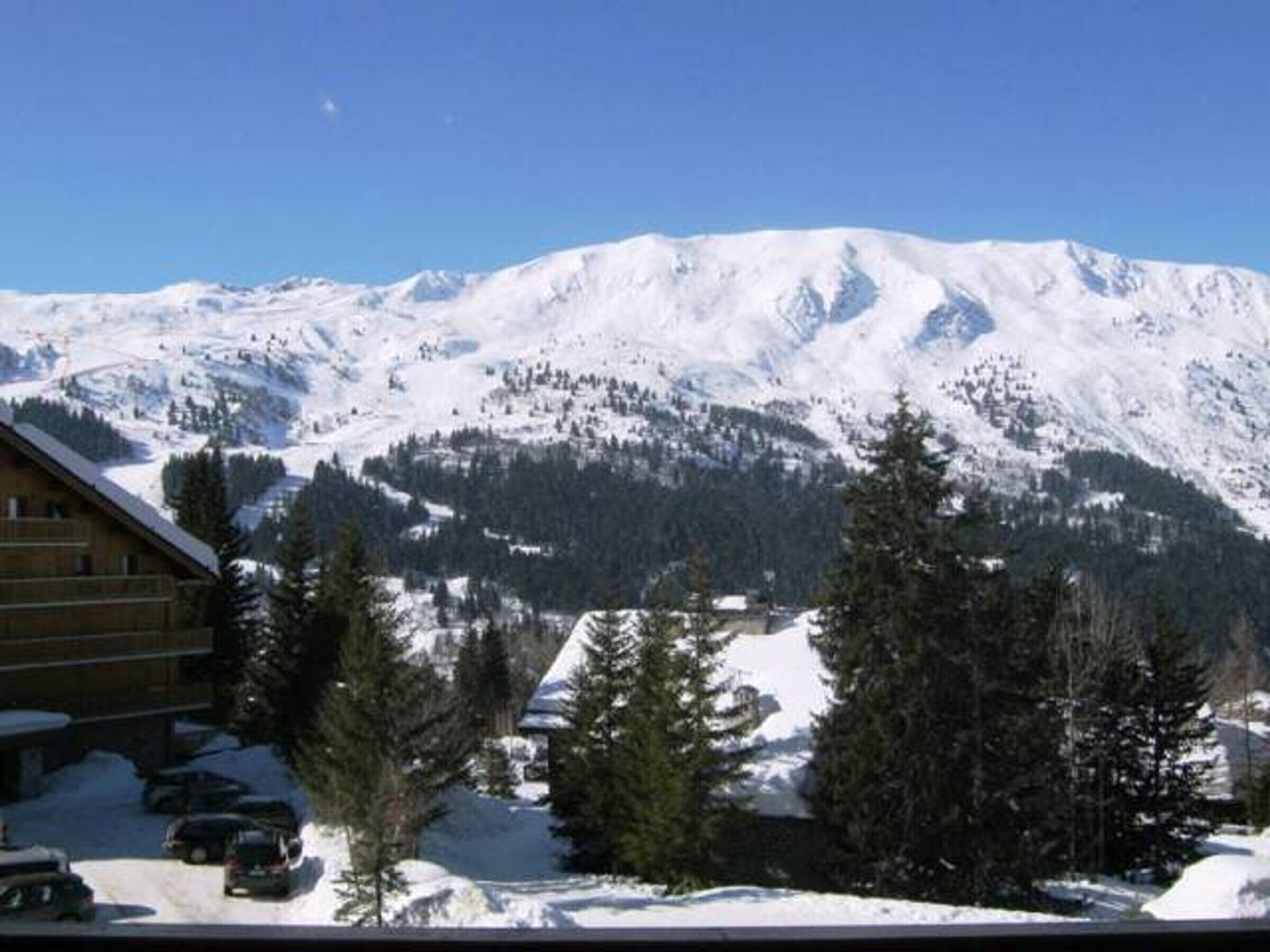 A mountain lodge with a view of snow-covered peaks.