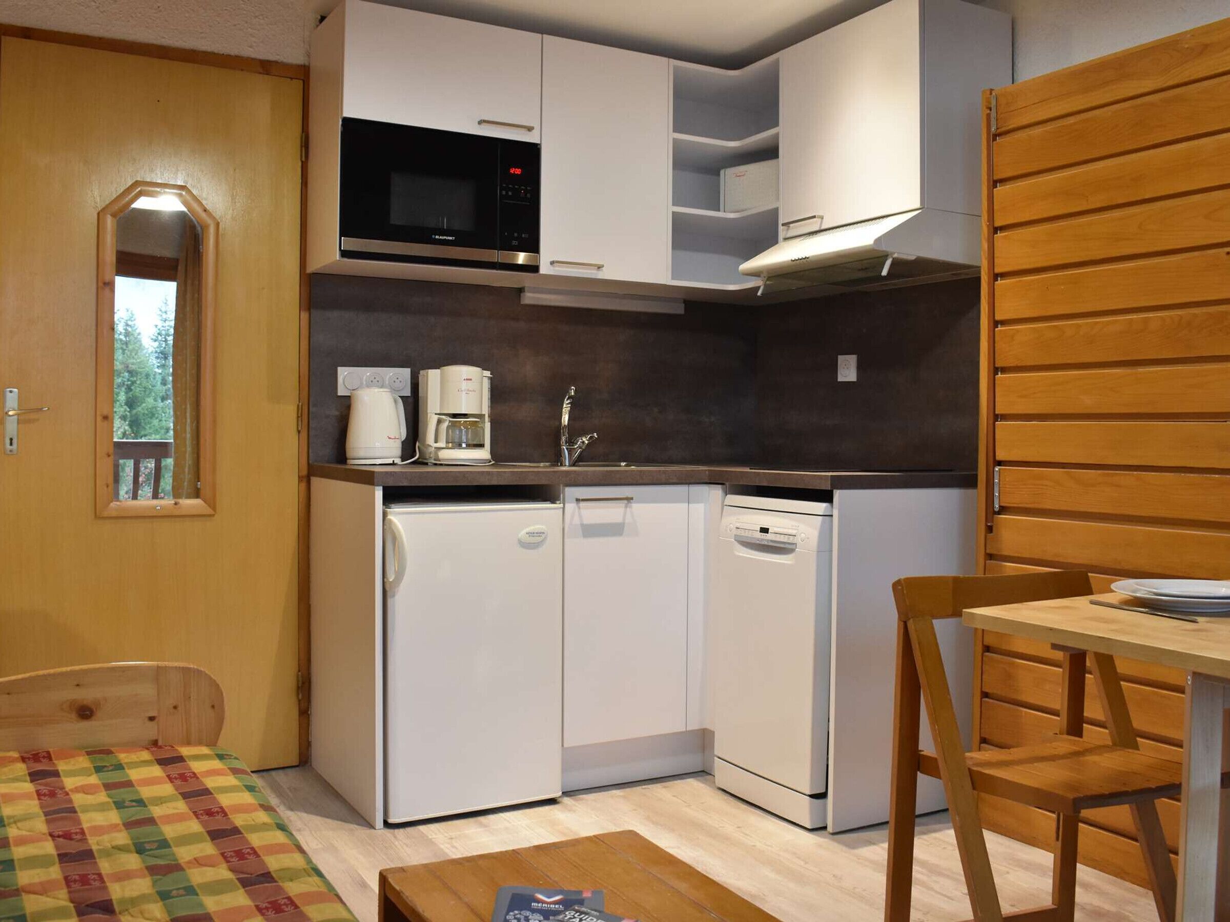 A compact kitchen with a microwave, coffee maker, and dishwasher.
