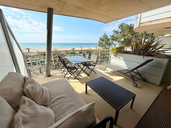 A balcony with a view of the sea, a table, chairs, and a lounge chair. - Luxury apartment with pool, pets allowed, air conditioning and parking in La Tranche-sur-Mer (La Tranche-sur-Mer)