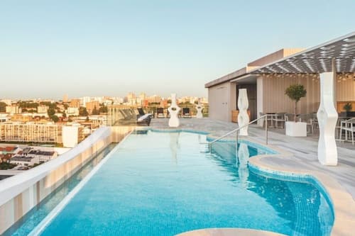 Una piscina al aire libre, tumbonas