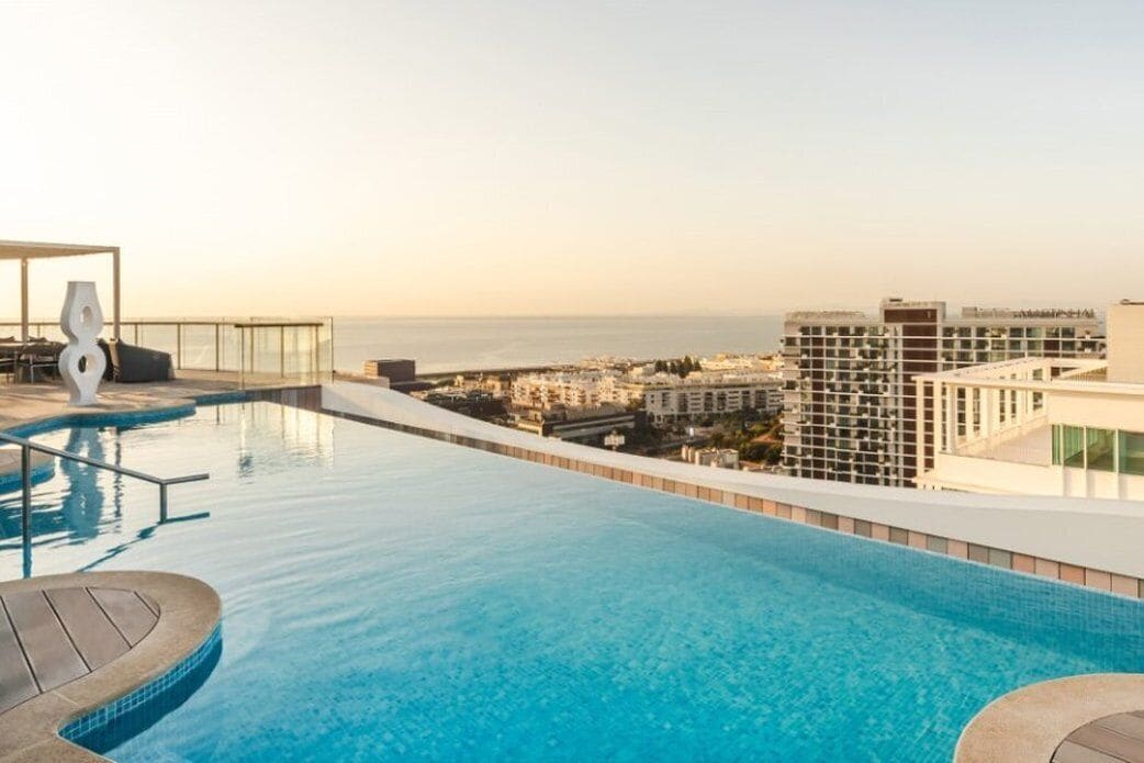 An infinity pool with a clear view of the cityscape and ocean.