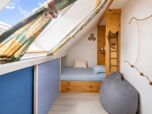 A small, cozy room with a sloped ceiling, a single bed, a wooden ladder, and a hammock. - Elegant and cosy 3 star house, walking distance from the Teven beach (Île-Tudy)