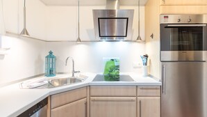 Een moderne keuken met roestvrijstalen apparatuur, een vaatwasser en een inbouwoven.