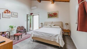 A bedroom with a bed, a desk, chairs, a window, and a painting on the wall. - Le Fonti - Sasso: large and bright (Pontassieve)