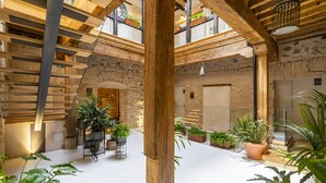 Un espacio interior amplio con techos altos, vigas de madera y plantas en macetas.