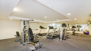 A gym with various exercise equipment including treadmills, weight machines, and free weights.