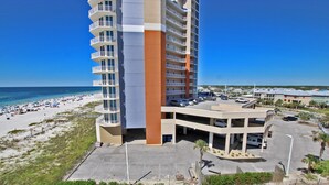 A high-rise hotel with multiple balconies overlooking a beach. - Condo in Gulf Shores | Beachfront Views from Private Corner Balcony | Sleeps 8 (Gulf Shores)