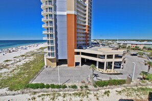 A high-rise hotel with multiple balconies overlooking a beach.