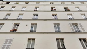 Un immeuble à plusieurs étages, doté de fenêtres et de balcons régulièrement espacés.