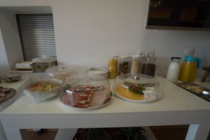 Uma mesa de buffet com alimentos cobertos e acompanhamentos.
