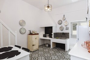 A compact kitchen with a microwave, sink, and a cabinet with decorative items. - The Residence of the Old Port (Rethymno)