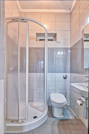 Ducha y bañera combinadas, toallas y papel higiénico