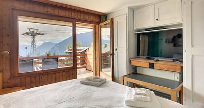 Wohnzimmer mit Bettcouch, zwei Betten im Vorraum, offene Küche mit 2 Kochplatten und Nespresso Kaffe