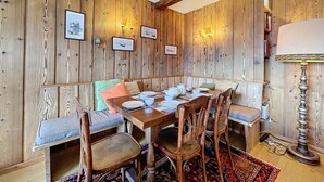 A wooden-paneled room with a dining table set for four, surrounded by wooden chairs and benches. - Royal 6, centrally located. Close to shops and restaurants (Verbier)