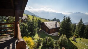 Une cabane en bois offrant une vue sur un paysage montagneux.