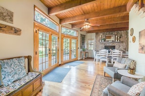 Relax in a spacious living area with high ceilings, large windows, and a cozy fireplace.