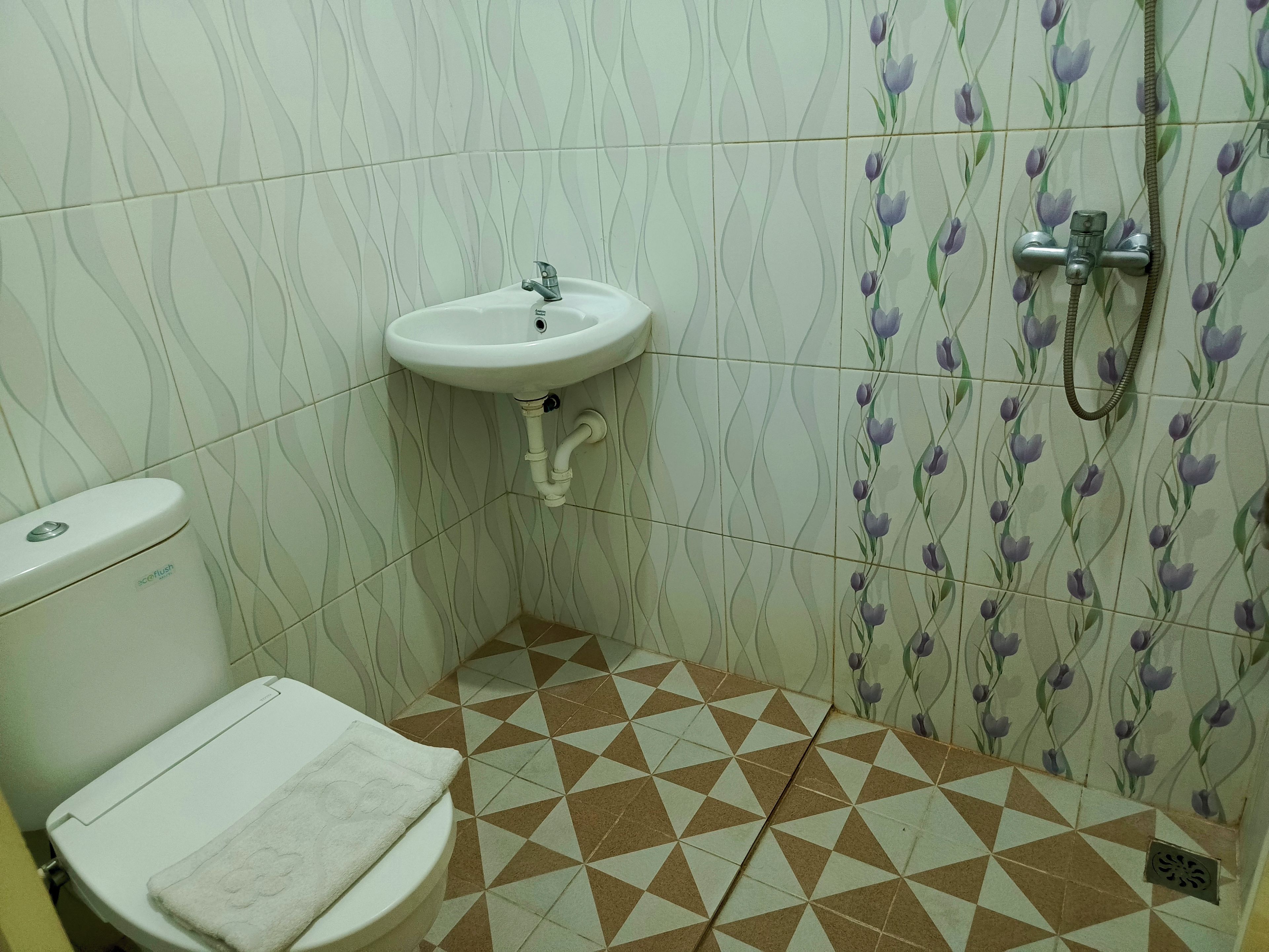 A bathroom with a toilet, sink, and shower.