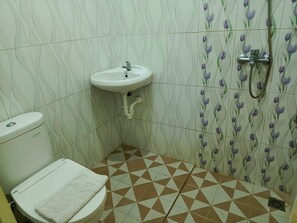 A bathroom with a toilet, sink, and shower. - Adisa Homestay by Zuzu (Malang)