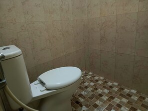 A bathroom with a toilet, a bidet, and tiled flooring. - Adisa Homestay by Zuzu (Malang)