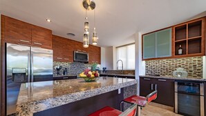 Una cocina moderna con una isla grande, electrodomésticos de acero inoxidable y un salpicadero original.