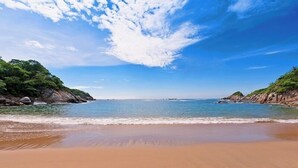 Una playa con cielos despejados y aguas tranquilas.