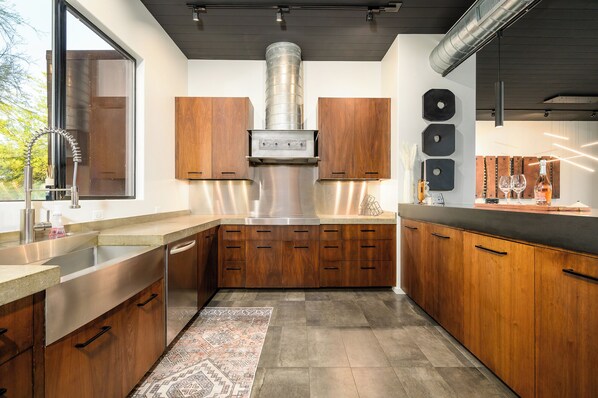 Una cocina moderna con armarios de madera, electrodomésticos de acero inoxidable y un amplio ventanal.