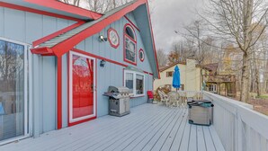 A deck with a barbecue grill, outdoor seating, and a covered area with a blue umbrella. - ARROWHEAD LAKE - Ski Chalet- Gameroom, Firepit - Lake View, Walk to Beach/Island (Pocono Lake)