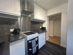 A modern kitchen with a built-in stove, a coffee maker, and a toaster on the countertop.
