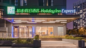 A Holiday Inn Express hotel entrance with a modern design, glass doors, and a well-lit facade. - Holiday Inn Express Shanghai Expo Centre by IHG (Shanghai)
