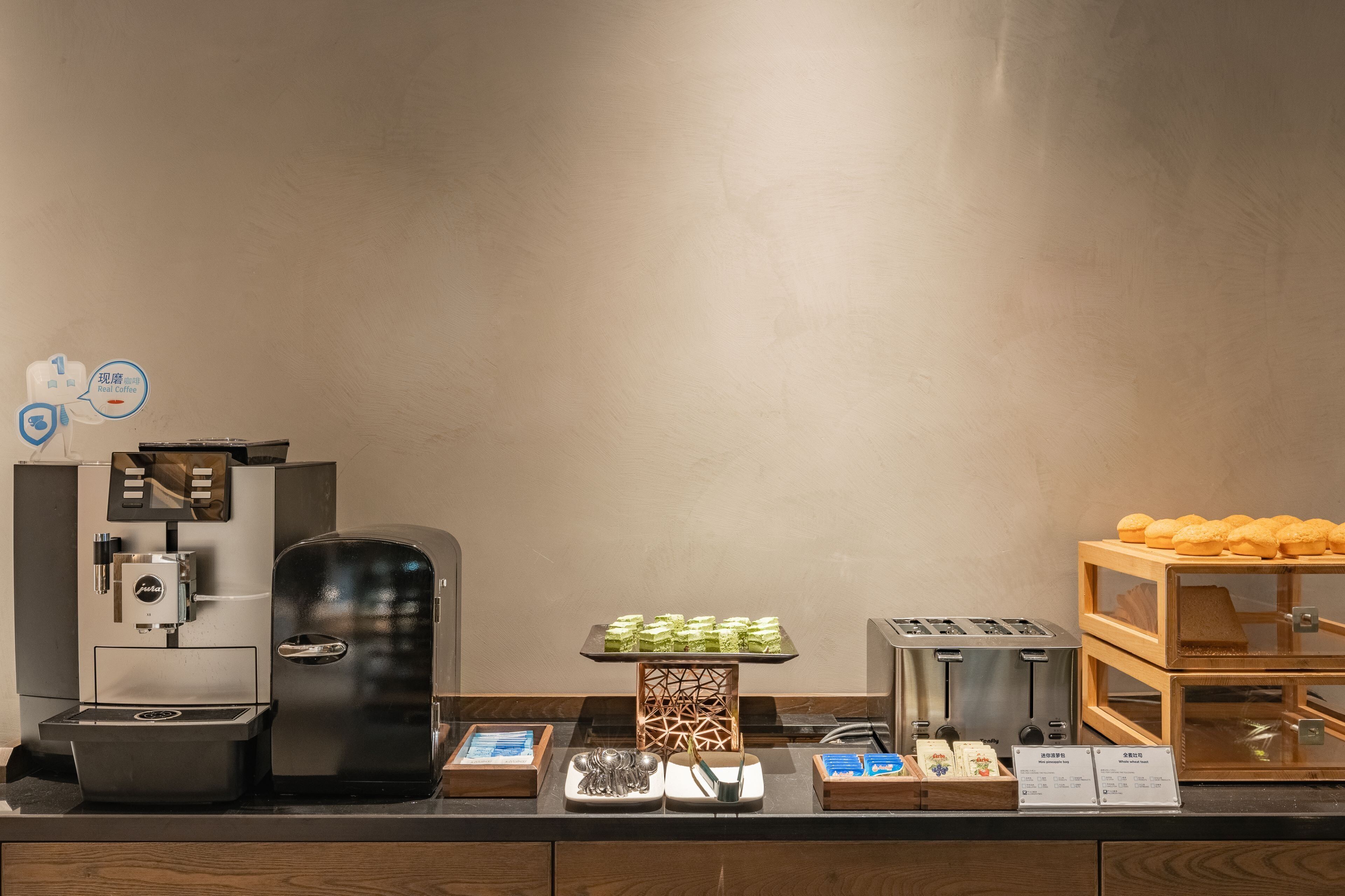 Un coin café équipé d’une machine à café, d’un plateau de viennoiseries, d’un grille-pain et d’une sélection de pains.