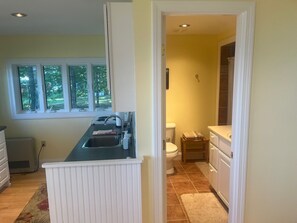 A kitchen with a window, a sink, and a stove.