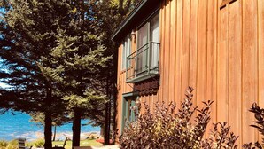 A wooden building with a balcony, a wooden deck, and a view of the water.