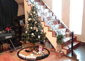 Cozy retreat with a Christmas tree, miniature train set, and Yamaha keyboard, perfect for families to unwind and create memories.