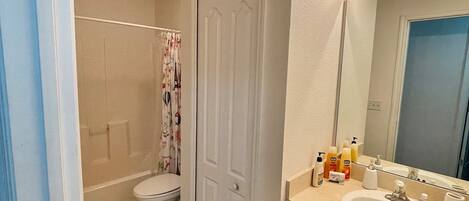 Een badkamer met toilet, douche en wastafel.