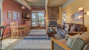 A cozy living room with a fireplace, wooden furniture, and a television.