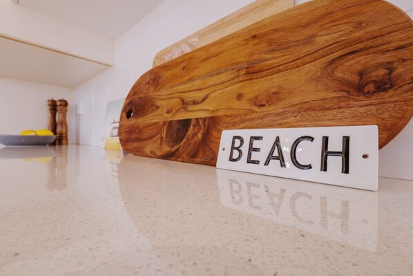 A polished wooden table with a white placard that reads 'BEACH' in a reflective font.